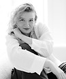 Monochrome portrait of smiling woman with curly hair indoors.