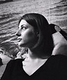Woman in profile looking left, black and white wavy water background.