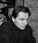 Black and white photo of a man looking pensively to the right.