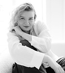 Monochrome portrait of smiling woman with curly hair indoors.